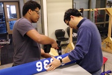 Danny Grimes, a blind student from Iowa City, gets help building a bumper for his team’s robot from Xuan Song, UI assistant professor of mechanical and industrial engineering