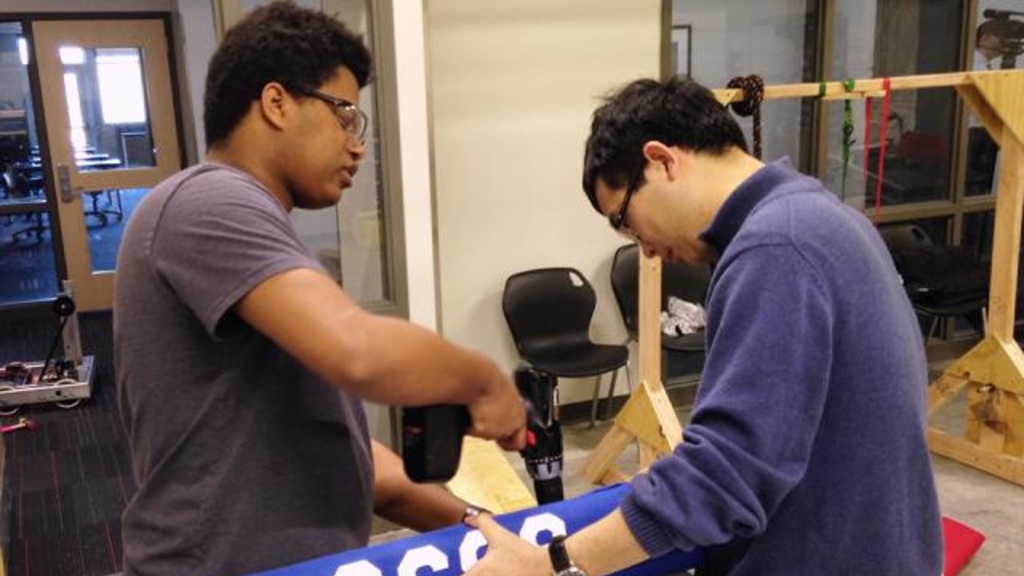 Danny Grimes, a blind student from Iowa City, gets help building a bumper for his team’s robot from Xuan Song, UI assistant professor of mechanical and industrial engineering